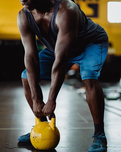 Side view of a man performing a slow, controlled squat.